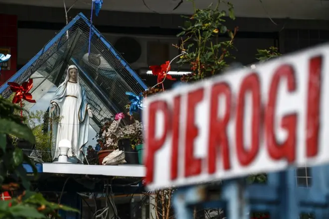 A atual casa da família, no Juvevê, divide espaço com a loja de pierogis, o chaveiro e a fé, com imagens sacras por todos os lados. Foto: Jonathan Campos/Gazeta do Povo.