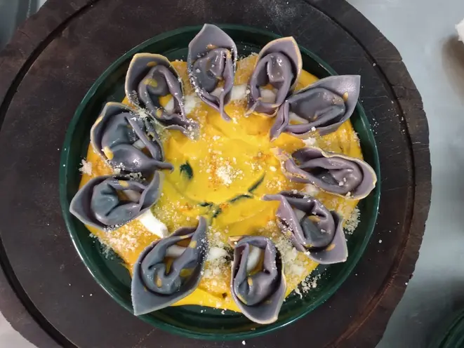 Tortelli com açafrão e sugo de cenoura. A massa fresca leva polpa de jenipapo verde e fica com uma tonalidade arroxeada. Foto: Claudio Oliver/Divulgação