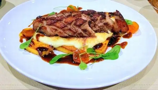 Magret de pato com polenta chapeada coberta de queijo Brie derretido, molho de laranja e compota de kinkan – o prato do mês do La Cecília Cantina & Café. Foto: Anacreon de Téos