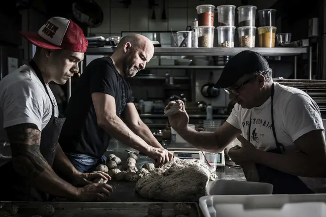 Junto de Gilmar e "Painho", Almeida diz que a convivência na cozinha passa longe da relação patrão-empregado. Foto: Letícia Akemi/Gazeta do Povo.