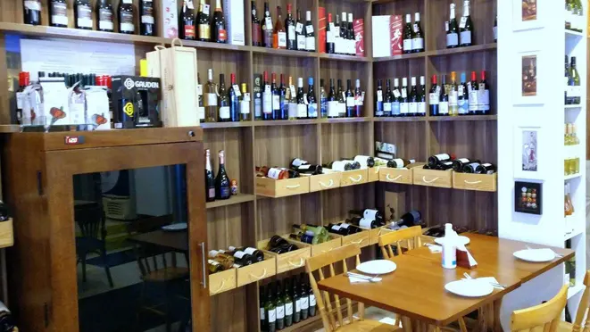 No salão interno, os vinhos fazem parte da decoração da casa.