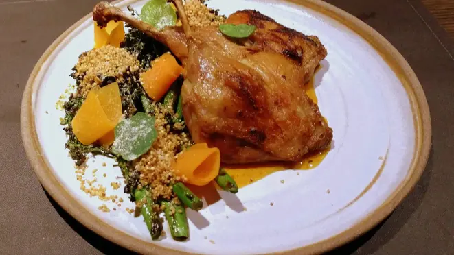 Coxa e sobrecoxa de pato confitadas, brócolis tostado na brasa e laqueado com missô, quinoa crocante, picles de abóbora e molho de laranja.
