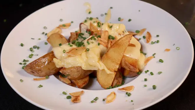 Raclette servida sobre bife de chorizo grelhado, alho confitado e batatas rústicas, do Valais Koffee Bar.