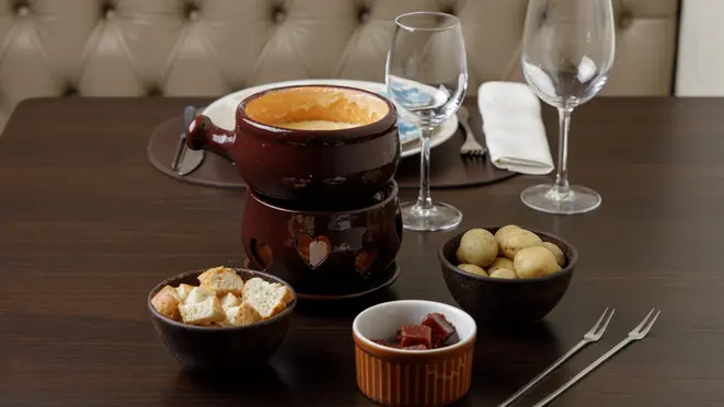 Fondue suíço acompanhado de pães, minibatatas e goiabada, do Château de Gazon.