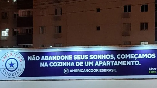 Outdoor da American Cookies em uma avenida de Brasília: mensagem para empreendedores.