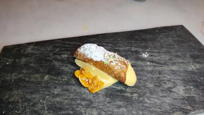 Cannoli recheado de creme praliné, acompanhado de compota de limão.