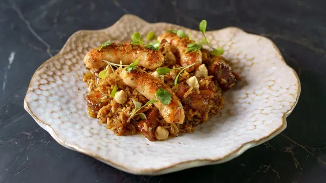 Arroz de costela de porco com linguiça de camarão e azeite de coentro - o prato principal do jantar harmonizado.