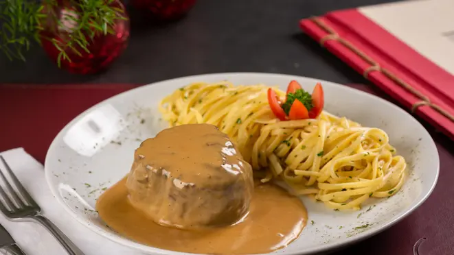 O restaurante serve filé mignon ao molho de queijo roquefort acompanhado de fettuccine.