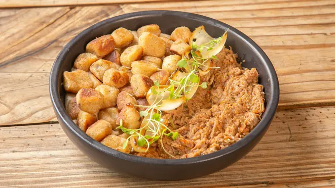 Nhoque feito com batata doce da estação, cebola tostada e microgreens. Acompanha bechamel de castanhas e carne de panela desfiada do Eat Kitchen.