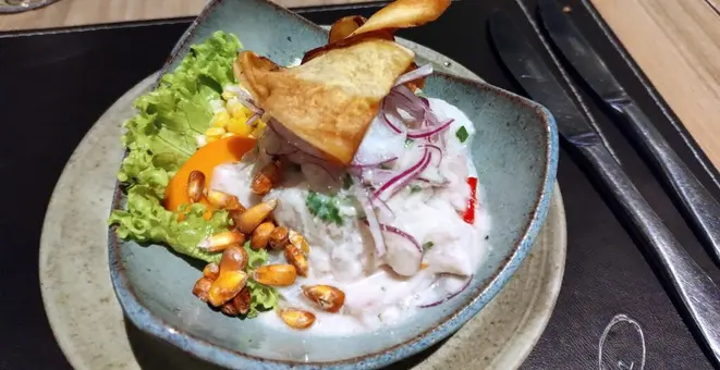 Ceviche norteño mixto (frutos do mar, camarões, lula e polvo, pimenta ají amarillo, leche de tigre, servido com couve crocante). | Foto: Anacreon de Téos