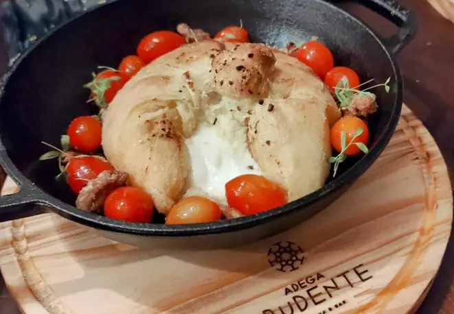A Burrata ao forno depois de cortada, com o recheio escorrendo. | Foto: Anacreon de Téos