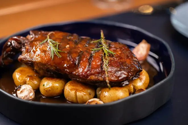Paleta de cordeiro assada em baixa temperatura e servida com batata-bolinha. | Foto: Larissa Sene