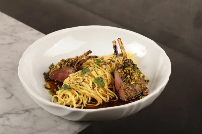 <em>Carré de cordeiro, pistache, amêndoas, linguine e demi-glace de cordeiro com azeite de menta</em>. | Foto: Divulgação