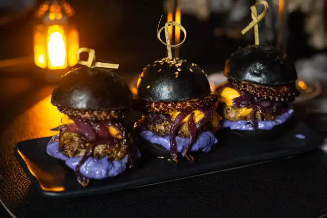 <em>Black octopus</em>: mini brioche preto com gergelim, maionese defumada roxa, cebola caramelizada, queijo cheddar e polvo. | Foto: Bruna Lima