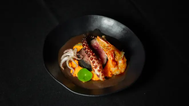 O <em>Trio of the Depths</em> combina tornedor de mignon no black rub, tentáculo de polvo, cabeça de lula, calamares, purê de cenoura e demi-glace. | Foto: Bruna Lima
